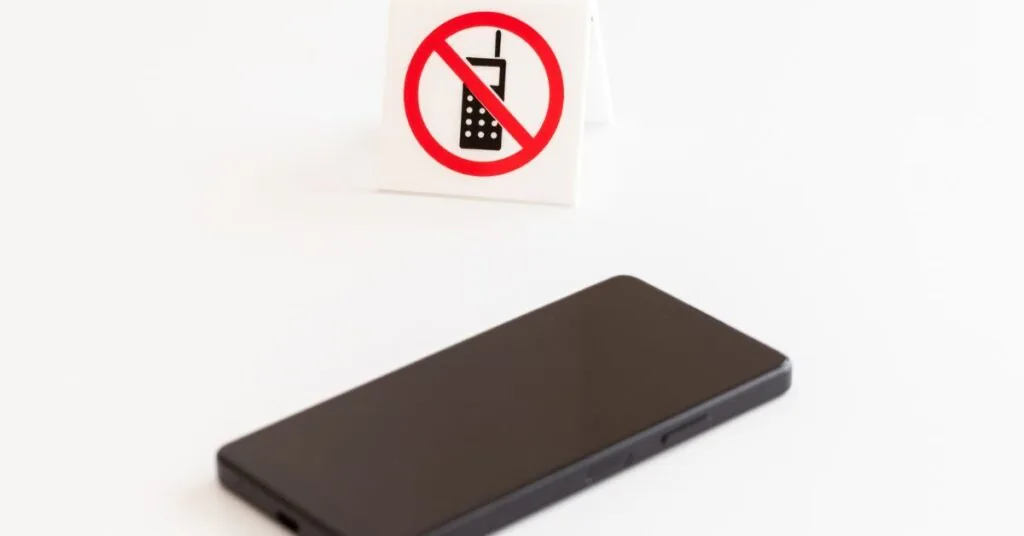 Mobiltelefon med förbudsskylt som visar mobilförbud