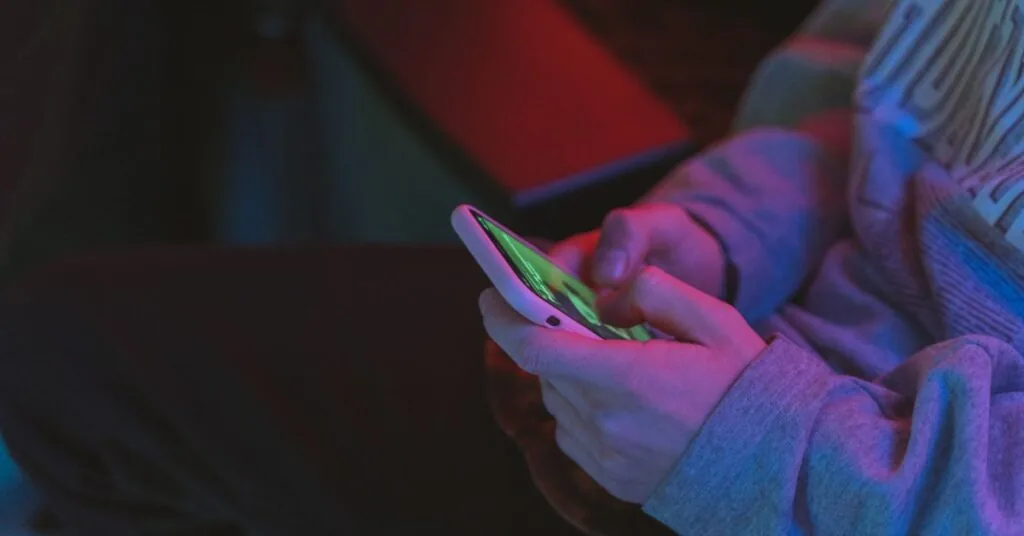 Ung person som använder mobiltelefon sent på kvällen