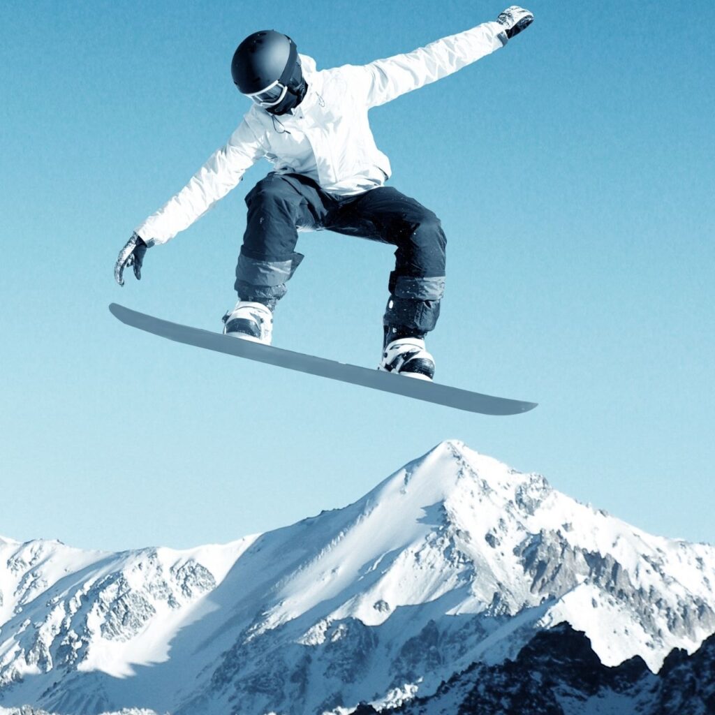 Snowboardåkare i luften efter ett imponerande hopp över ett snögupp