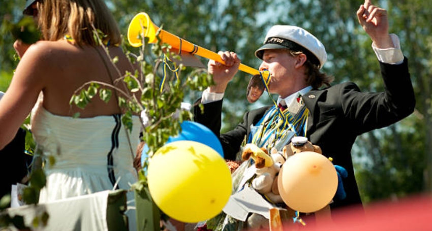Manlig student firar studenten med studentmössa