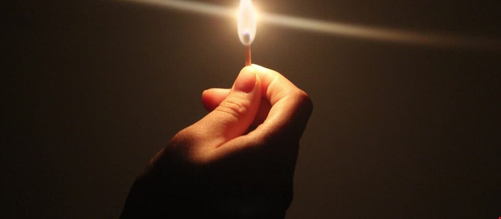 man tänder en tändsticka