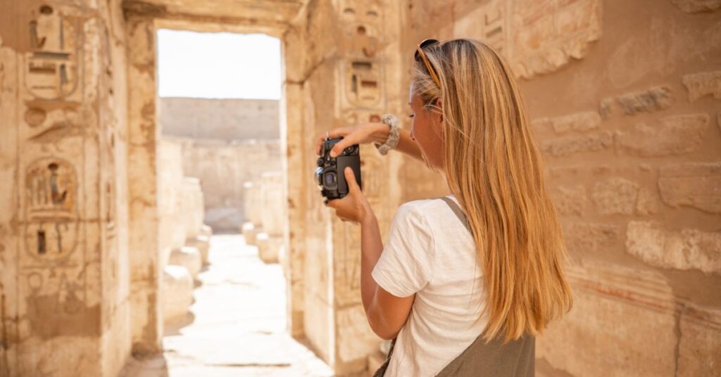 Ung resenär fotograferar ett historiskt tempel under en kulturell gruppresa utomlands