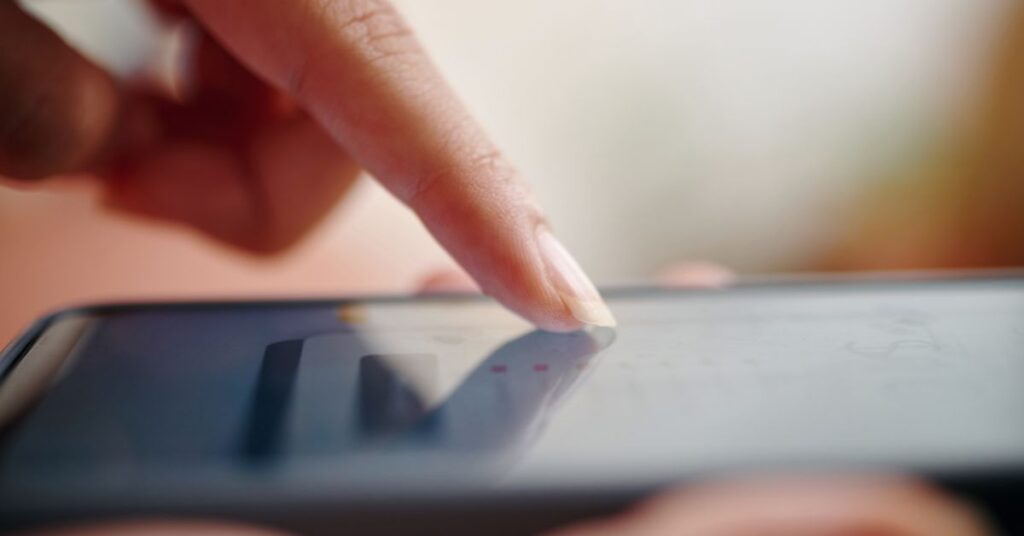 Närbild på finger som använder mobiltelefon