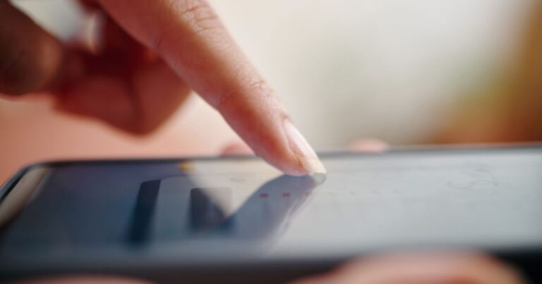 Närbild på finger som använder mobiltelefon