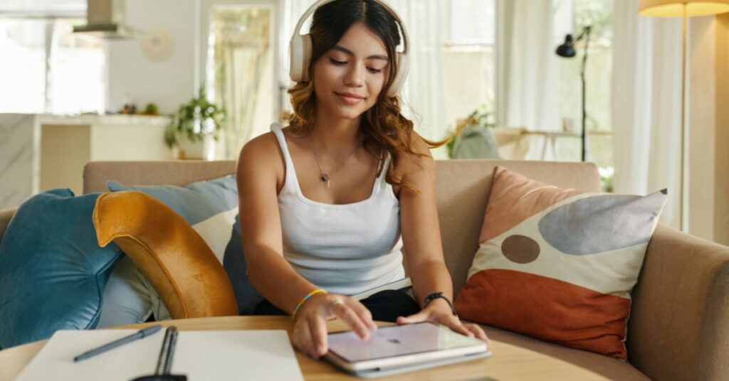 Elev pluggar hemma med läxhjälp och hörlurar