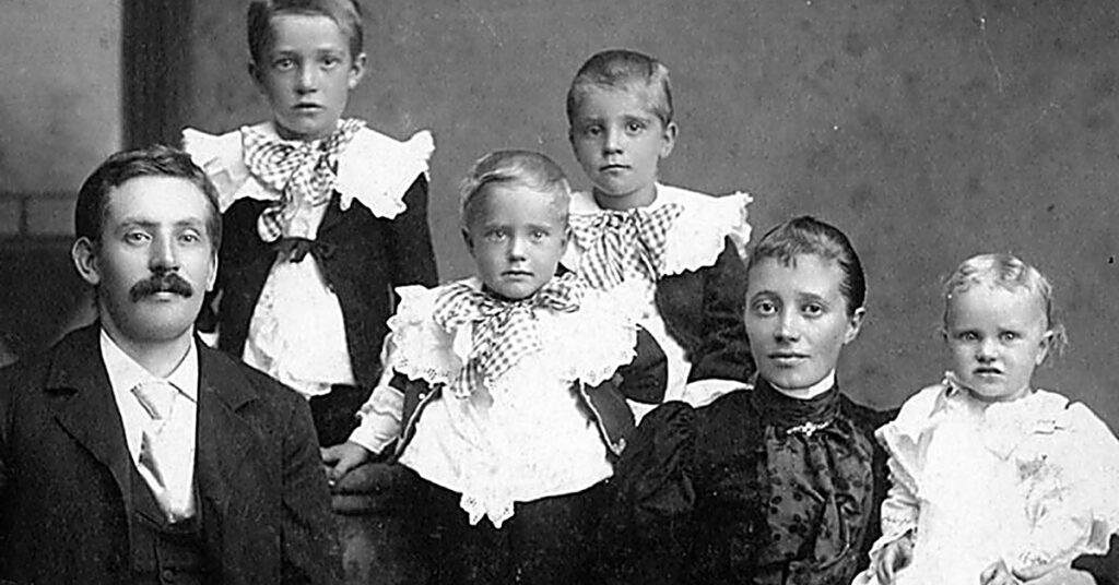 Familjeporträtt i studio från tidigt 1900-tal med föräldrar och fyra barn